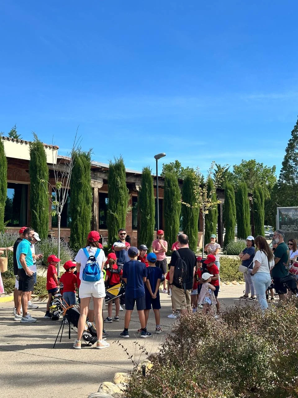 Familias y jóvenes en la entrada del club
